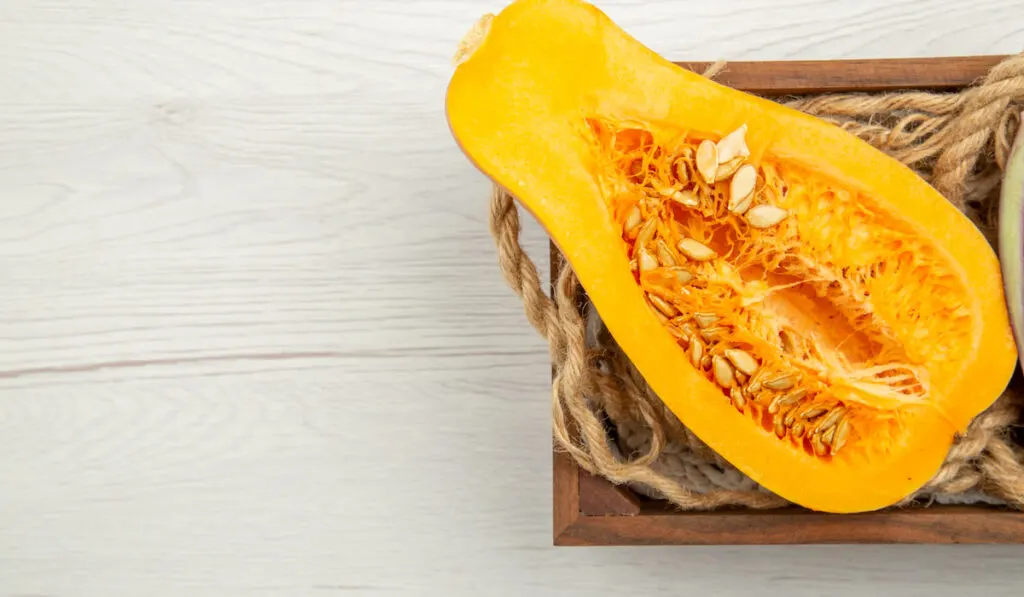 butternut squash cut in half in wooden box