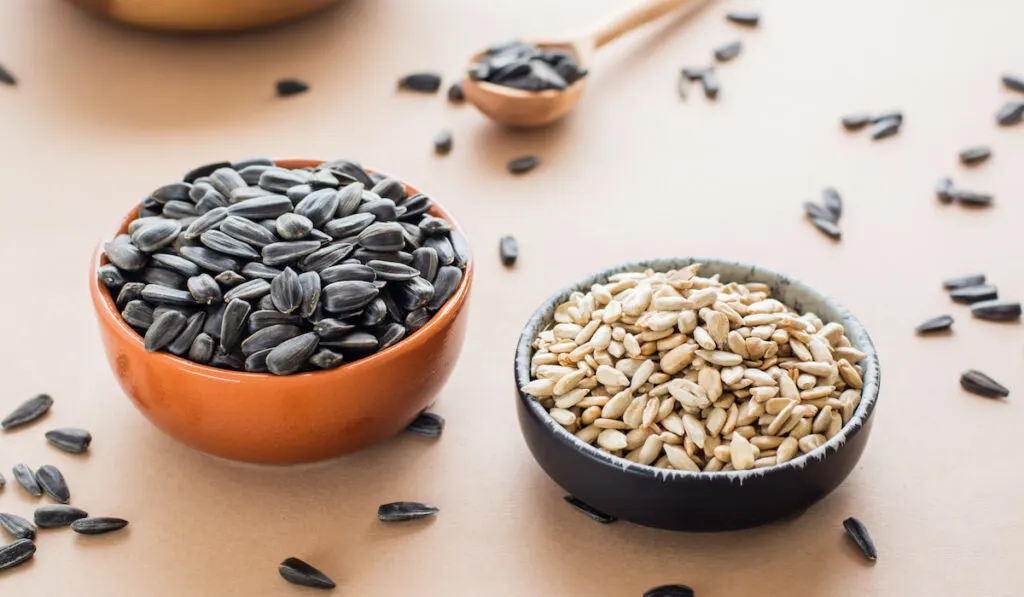 peeled and unpeeled sunflower seeds in bowls on the table