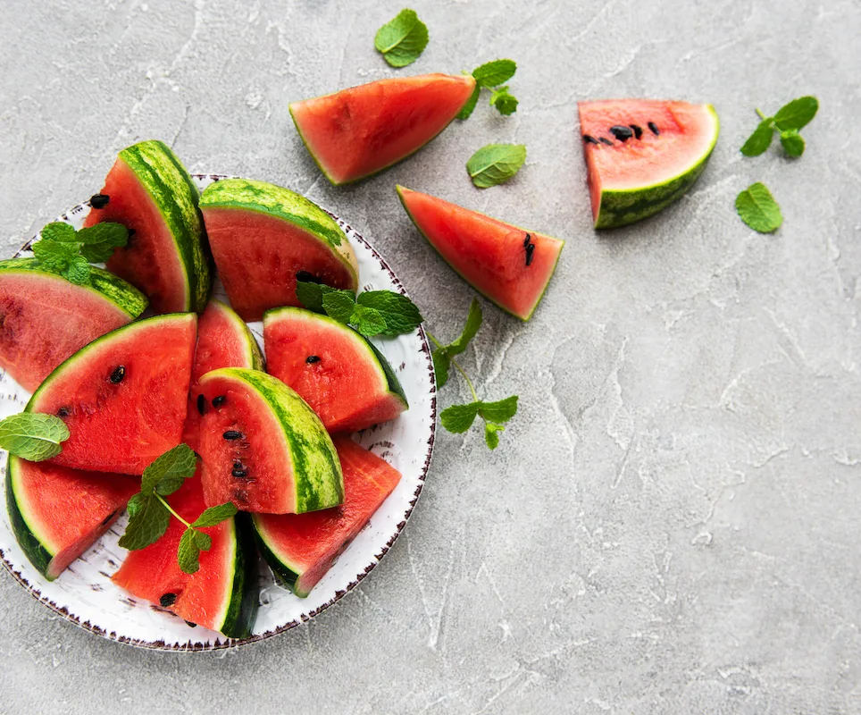 sliced watermelon on plate decorated with mint