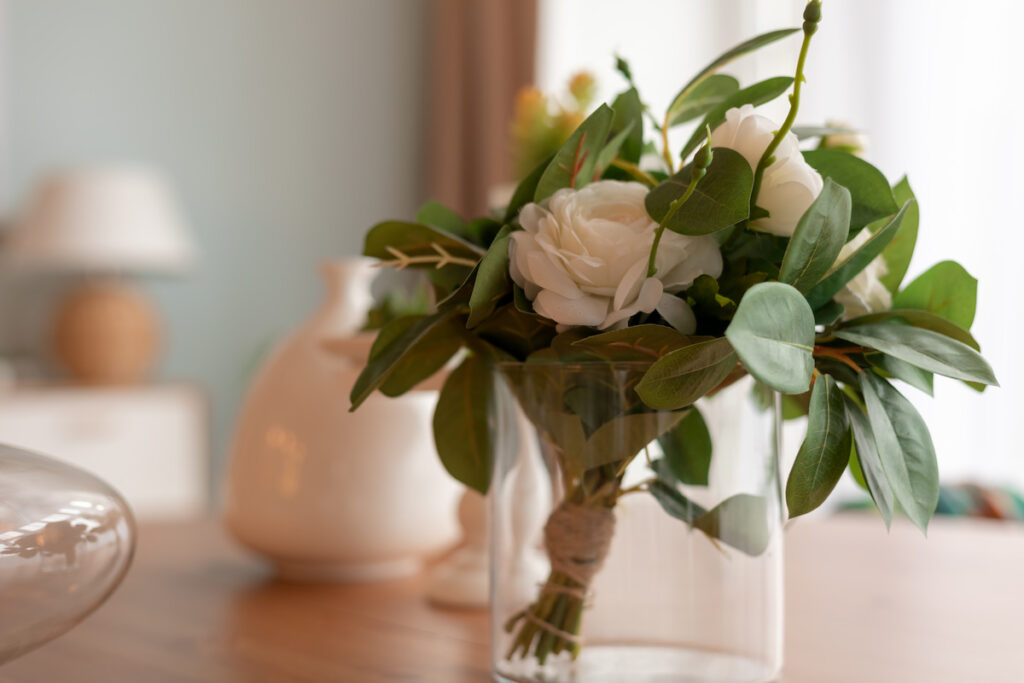 An empty candle jar as a flower vase with white flower