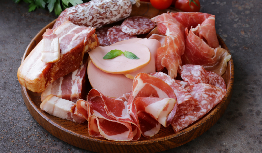 Assorted deli meats on a wooden plate