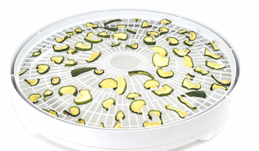Dehydrated cucumber slices on food dehydrator tray
