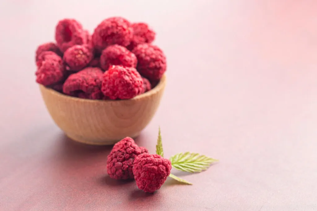 Dehydrated raspberries in a wooden small bowl 