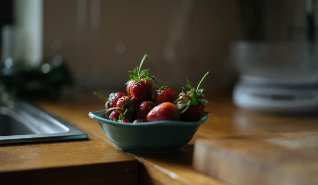 bowl of strawberries in the kitchen counter at a room temperature