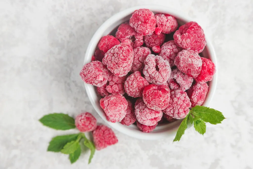 Frozen raspberries in a glass bowl