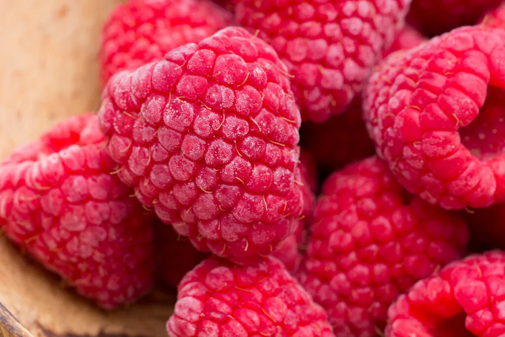 Frozen raspberries in a wooden bowl 