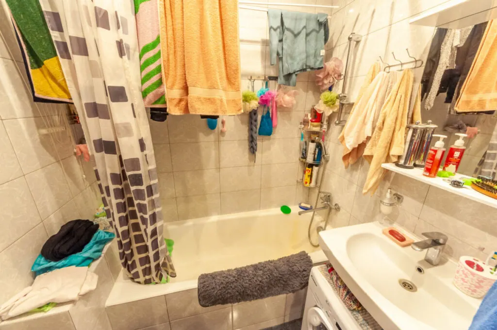 Messy bathroom with towels hanging