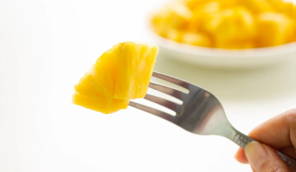 Pineapple with Cutlery on blur image of Pineapple in white plate with white background