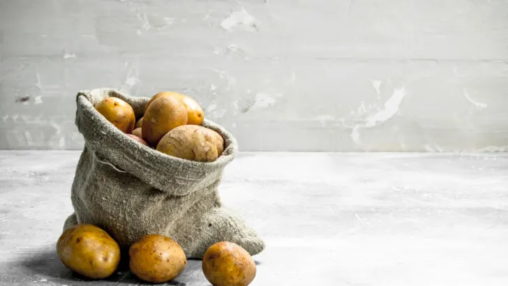 potatoes in the sack on a white rustic background