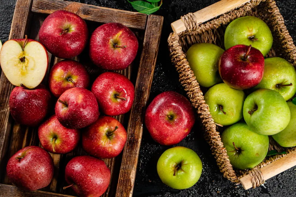 Red and green apples separated in baskets on top of the table