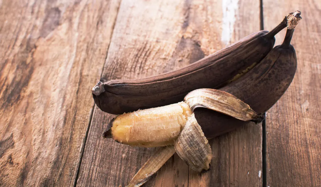 Spotted brown banana on wooden table