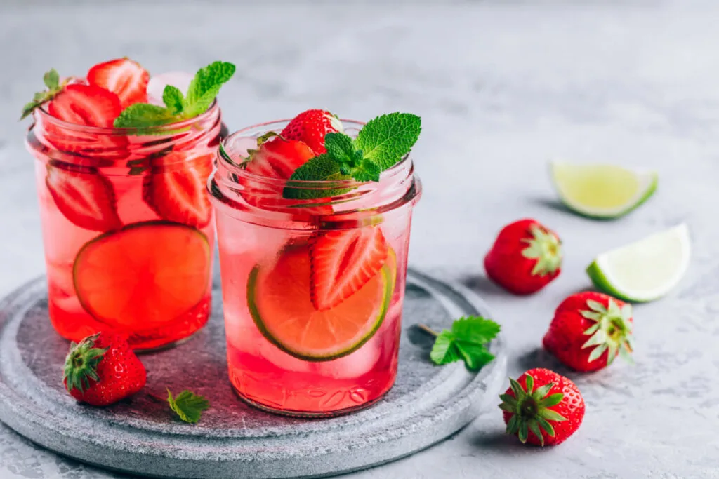 Strawberry mint cocktail drink in an empty candle jar 