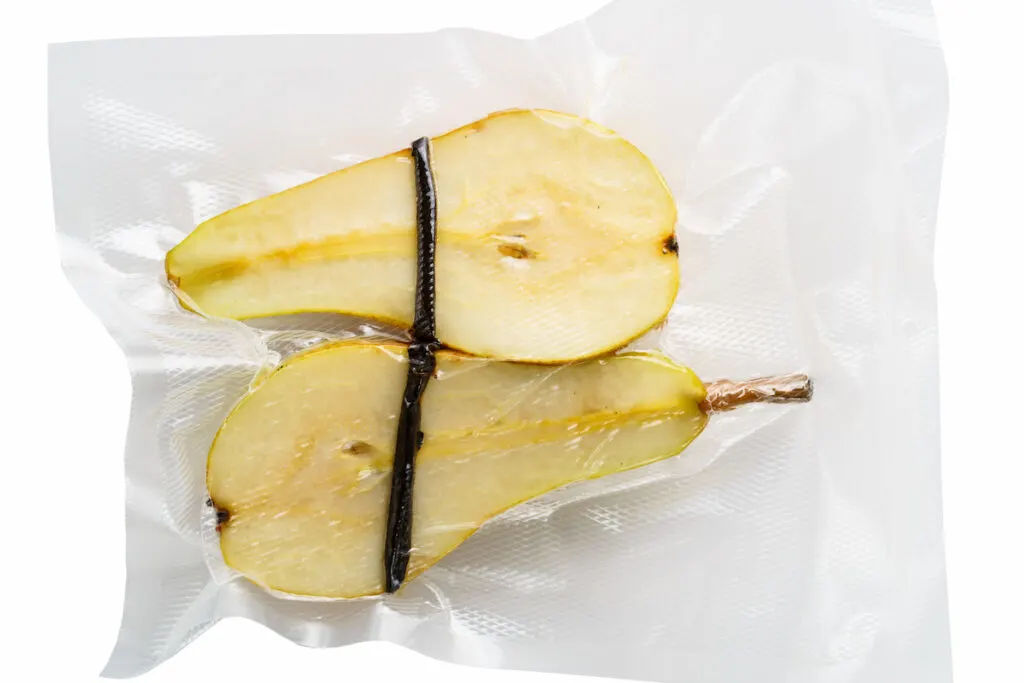 Vacuum sealed fresh pears with vanilla on white background