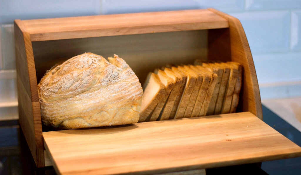 Wooden bread box with bread in the kitchen.
