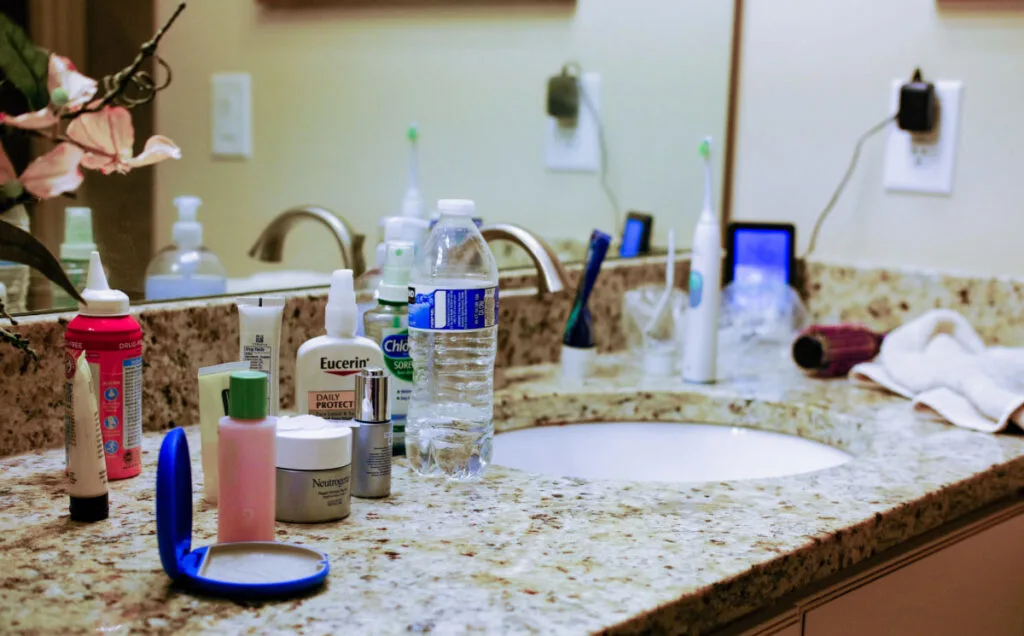 a messy bathroom countertop with make ups