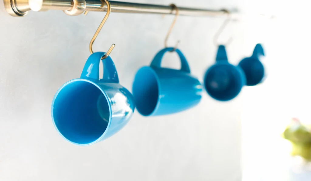 empty blue cups hanging in kitchen