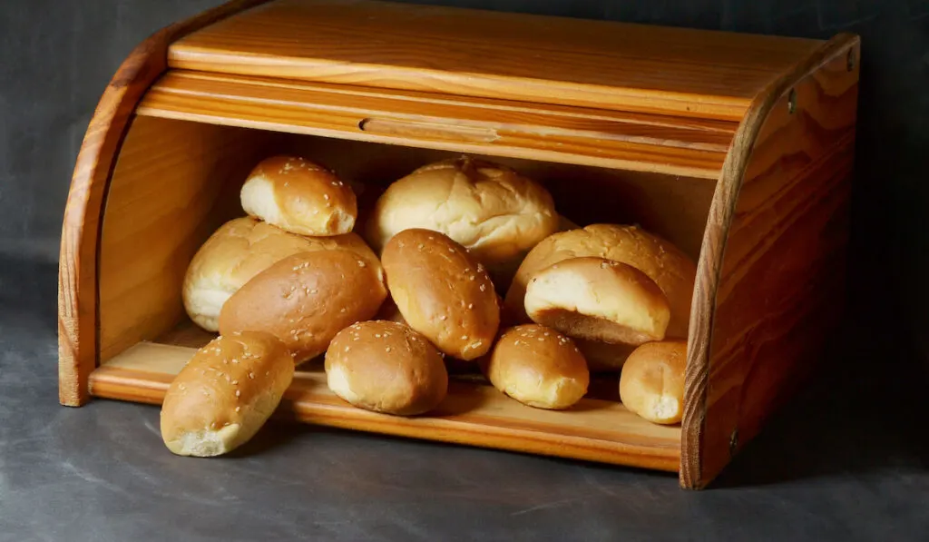 fresh baked sesame buns in wooden box
