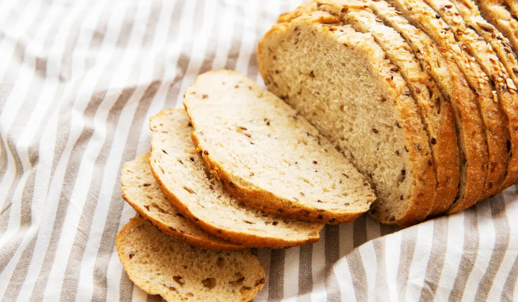 sliced wholegrain bread on a cloth on wooden table