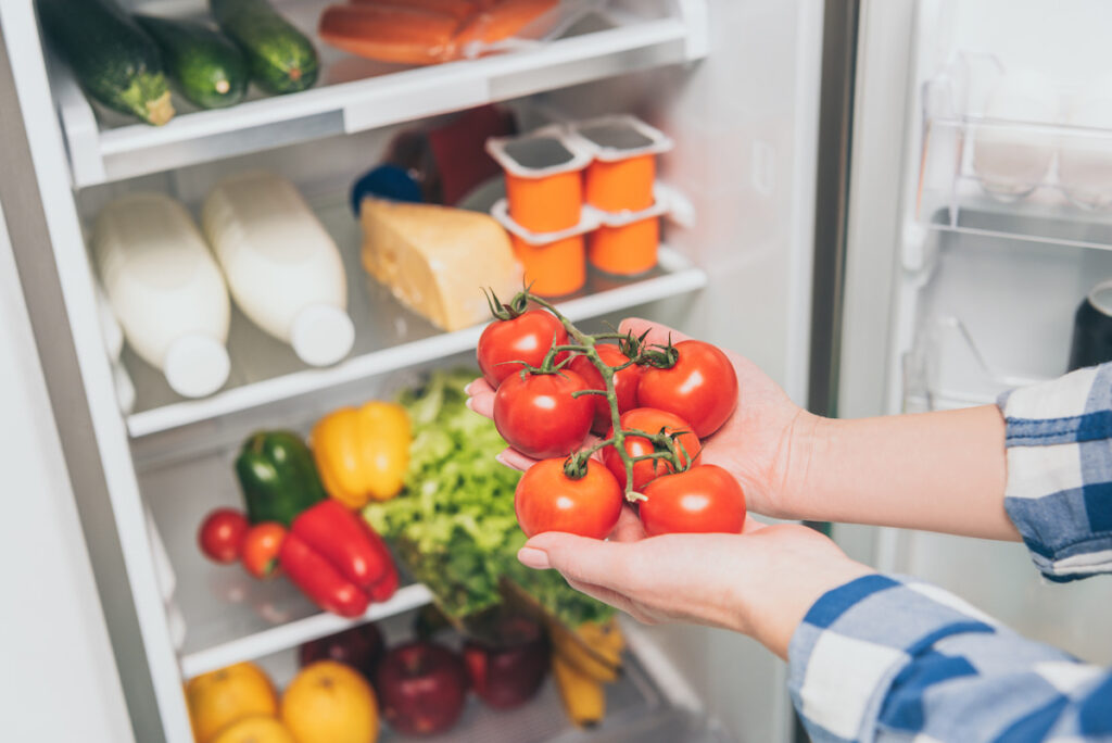woman putting tomatoes in the fridge
