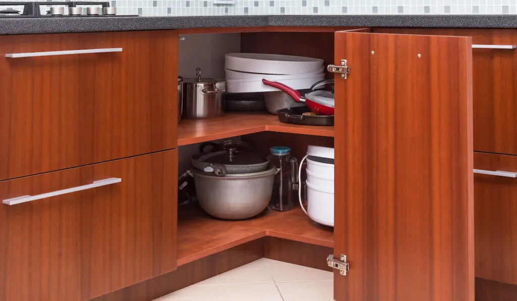 Corner storage mechanism of a kitchen cabinet