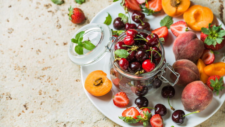different healthy and fresh fruits in a jar on a white plate