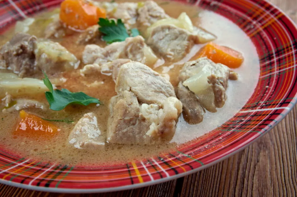 Kentucky Burgoo stew in a red striped plate 