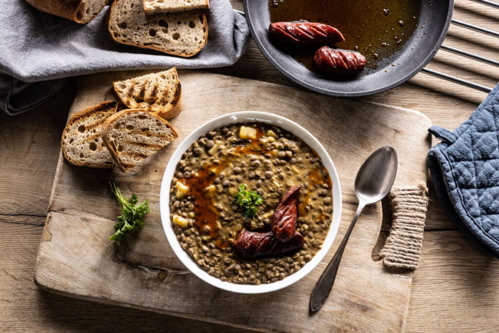 Lentil Sausage Soup in a bowl with bread at the side 