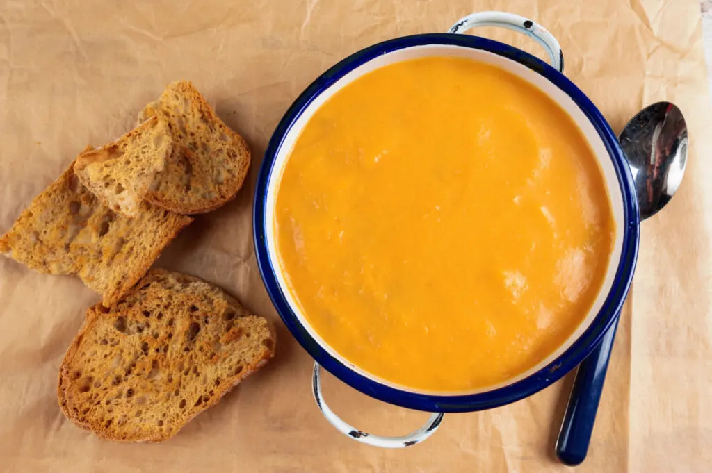 Summer squash soup in a bowl with handle bread at the side 