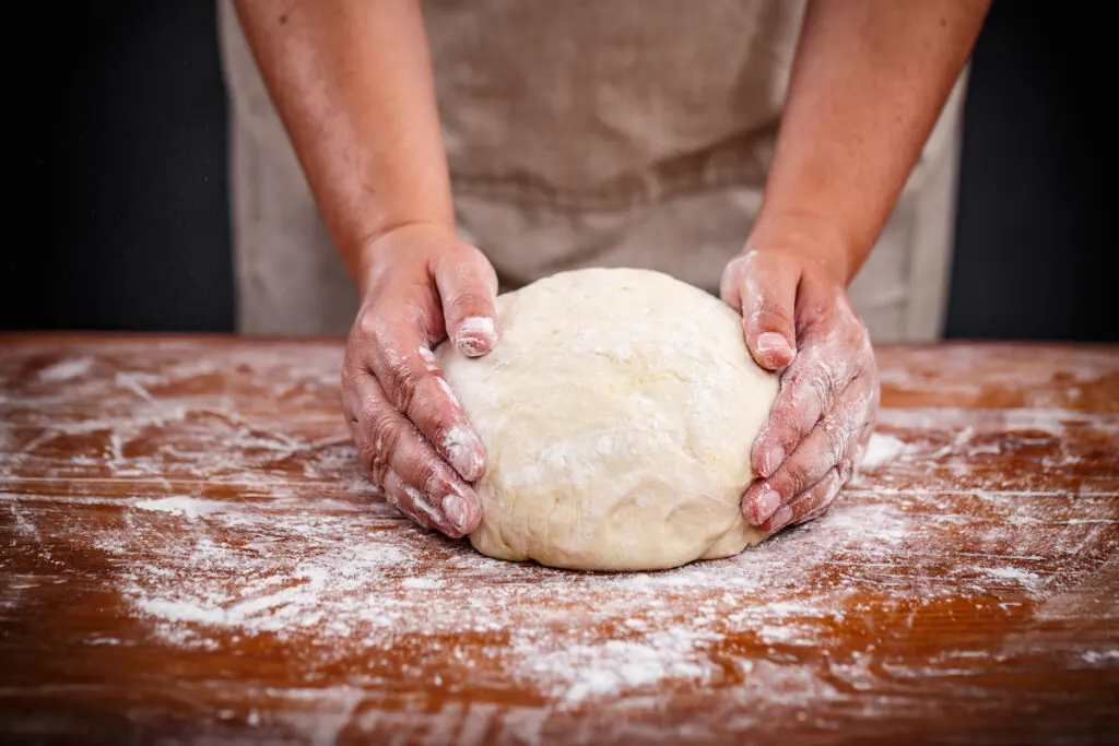 a baker preparing the bread dough using his hands
